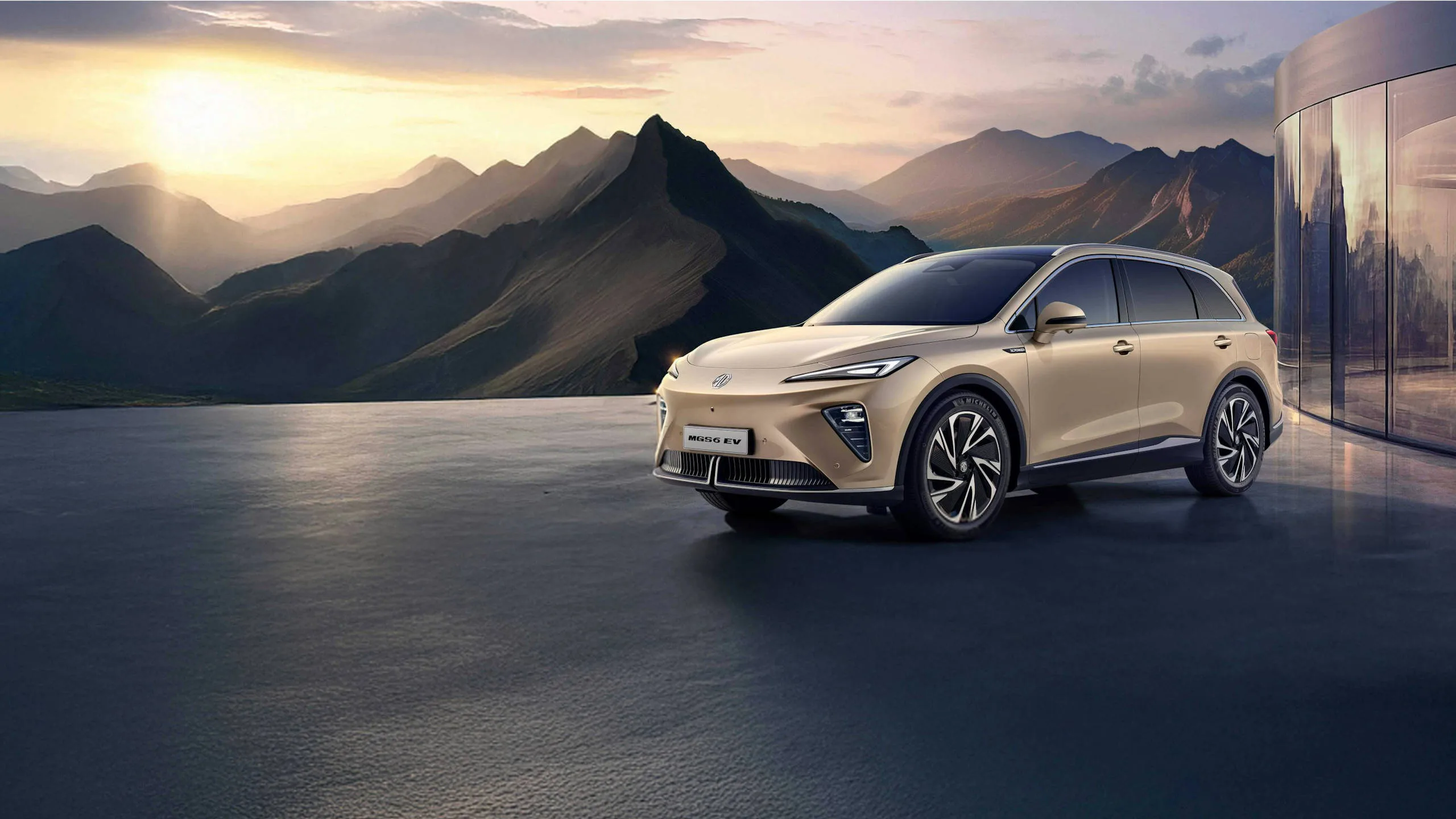 Elektrisk SUV MG EV kjører langs fjellandskap – beige karosseri, LED-frontlys og store felger