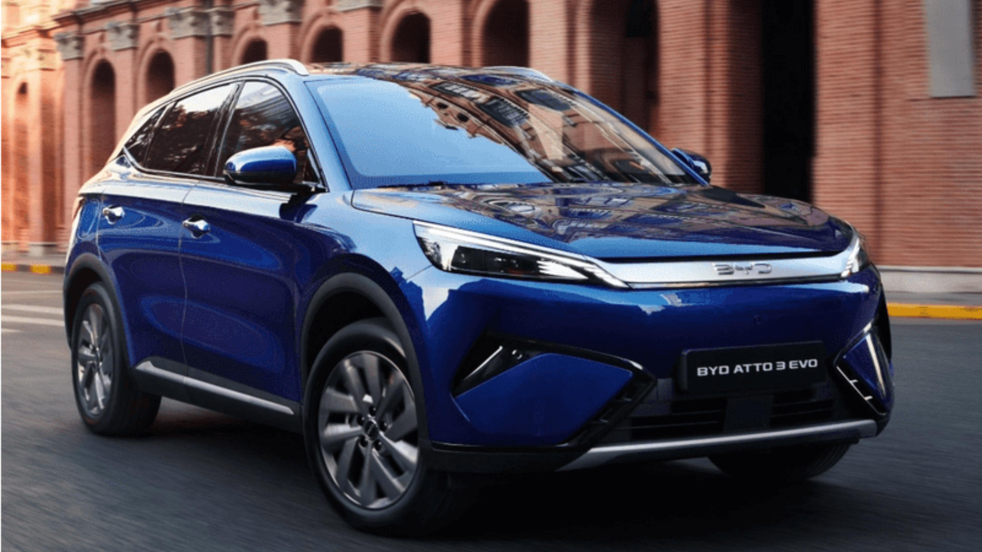 BYD EVO 4x4 i blått som kjører gjennom bymiljø med moderne arkitektur.