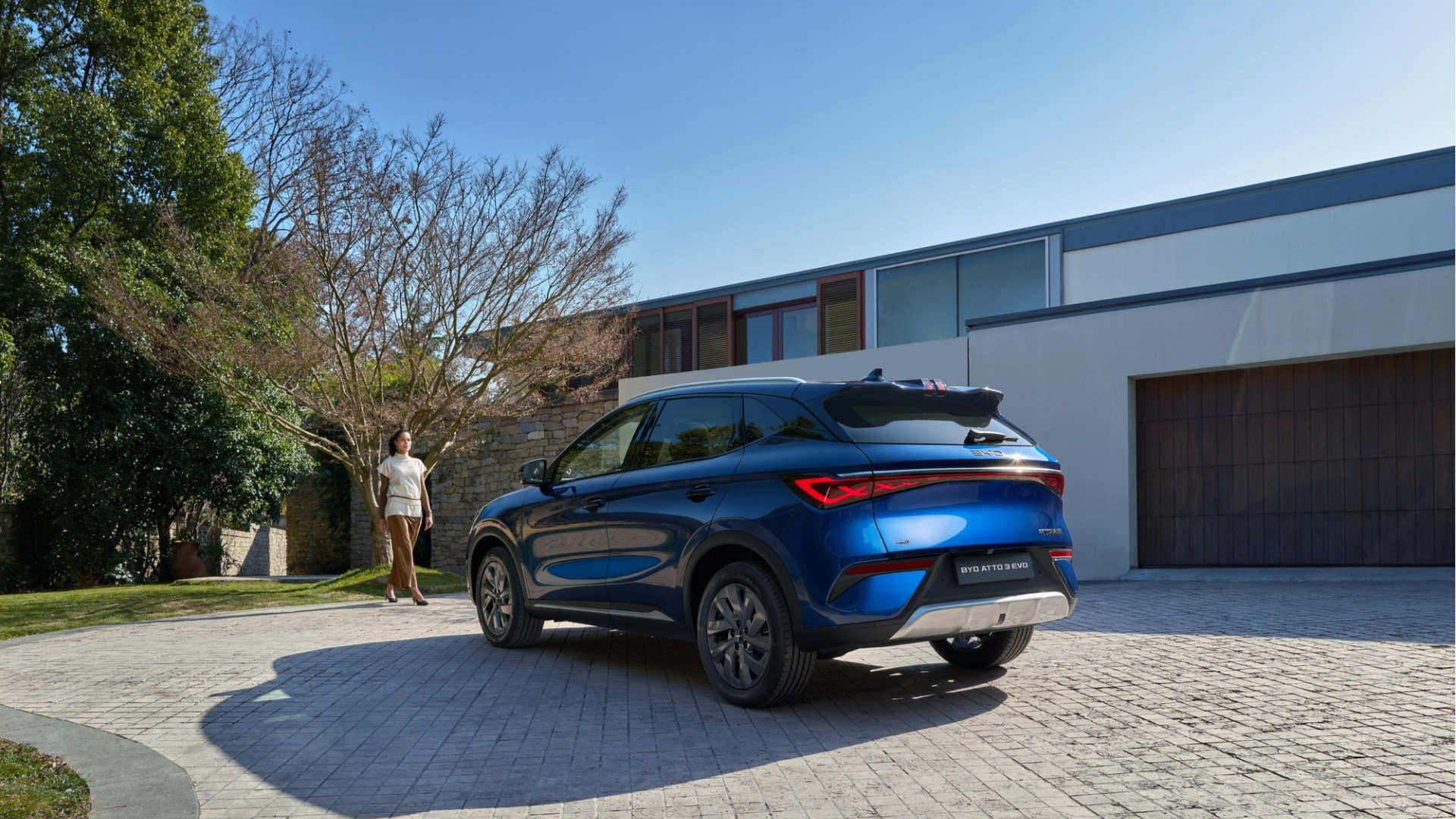 BYD EVO 4x4 i blått parkert foran moderne bolig med trær og sollys.